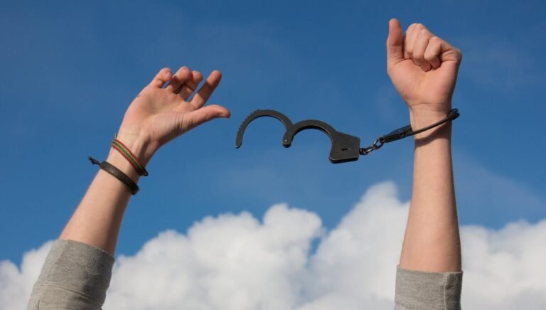 Quando o amor não é recíproco: como lidar com a dor e se libertar – mãos levantadas quebrando algemas simbolizando liberdade emocional