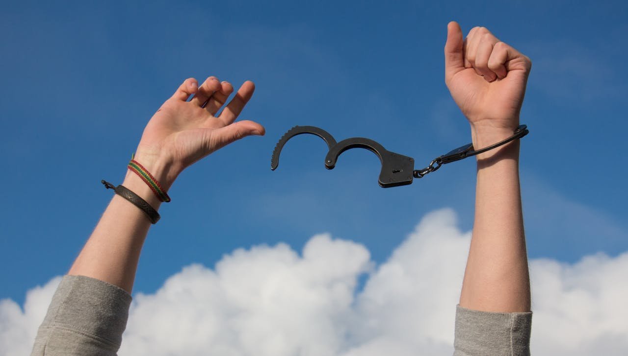 Quando o amor não é recíproco: como lidar com a dor e se libertar – mãos levantadas quebrando algemas simbolizando liberdade emocional