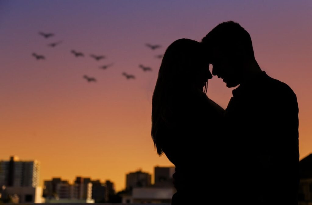 Por que você sempre se apaixona por quem não te corresponde?
Casal em silhueta ao pôr do sol, representando o desejo de conexão amorosa não correspondido.