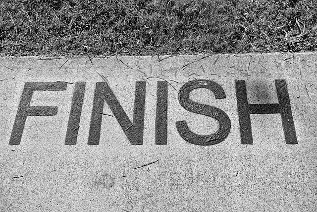 Palavra "FINISH" escrita no chão de concreto, simbolizando o fim de um ciclo ou jornada.