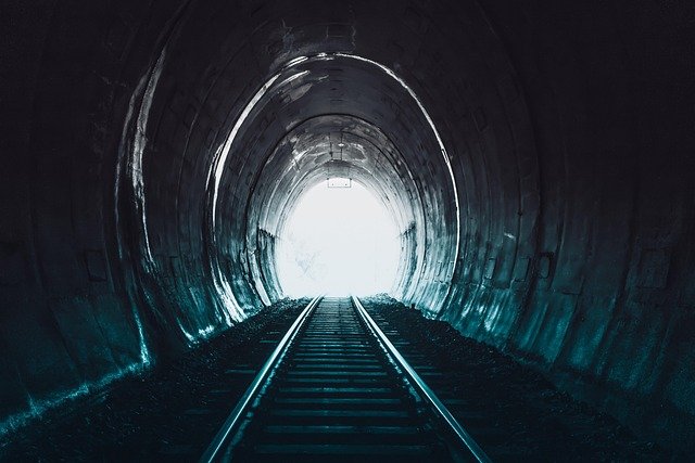 Túnel escuro com luz no fim, simbolizando recomeço, esperança e recuperação da autoestima após o fim de um relacionamento.