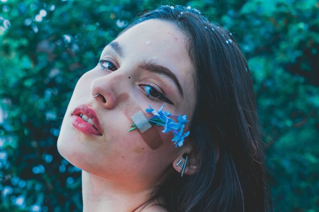 Superar Término. 
Mulher com curativo no rosto e flores brotando, representando a dor emocional de um término e o processo de cura interior